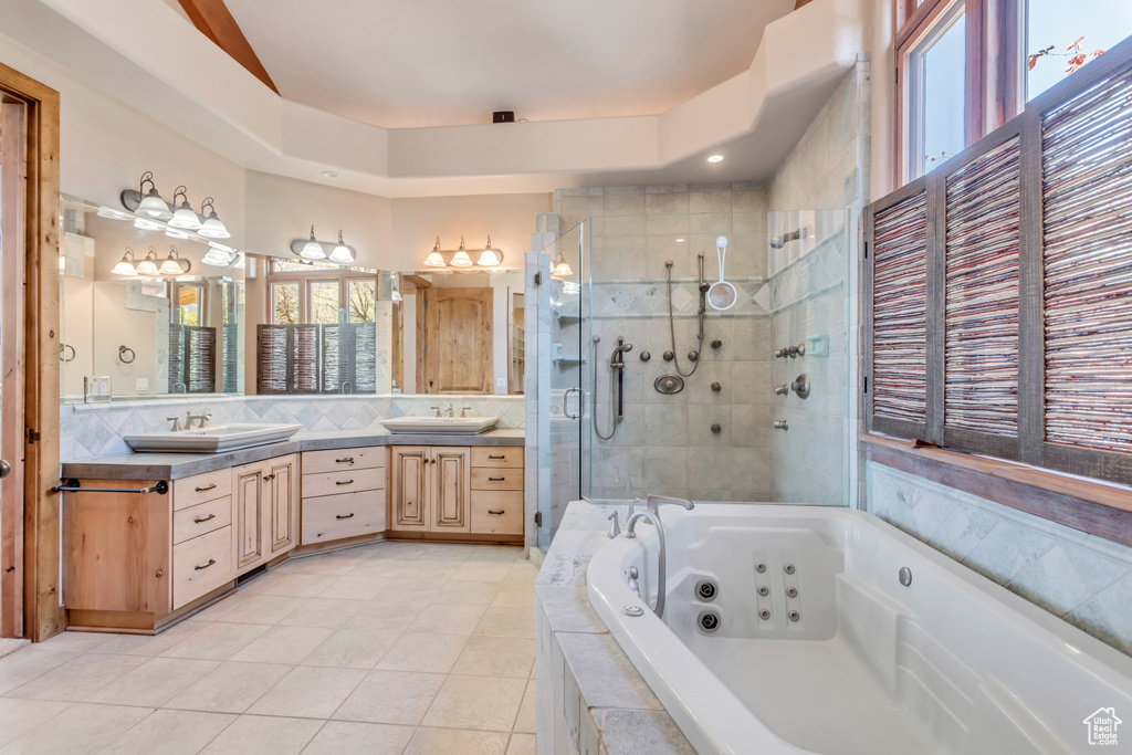Bathroom featuring backsplash, plus walk in shower, double vanity, and tile flooring