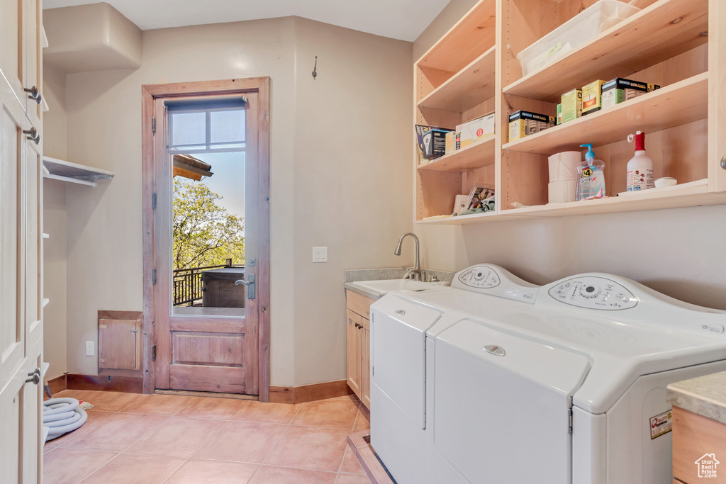 Laundry room featuring plenty of natural light, separate washer and dryer, sink, and light tile flooring