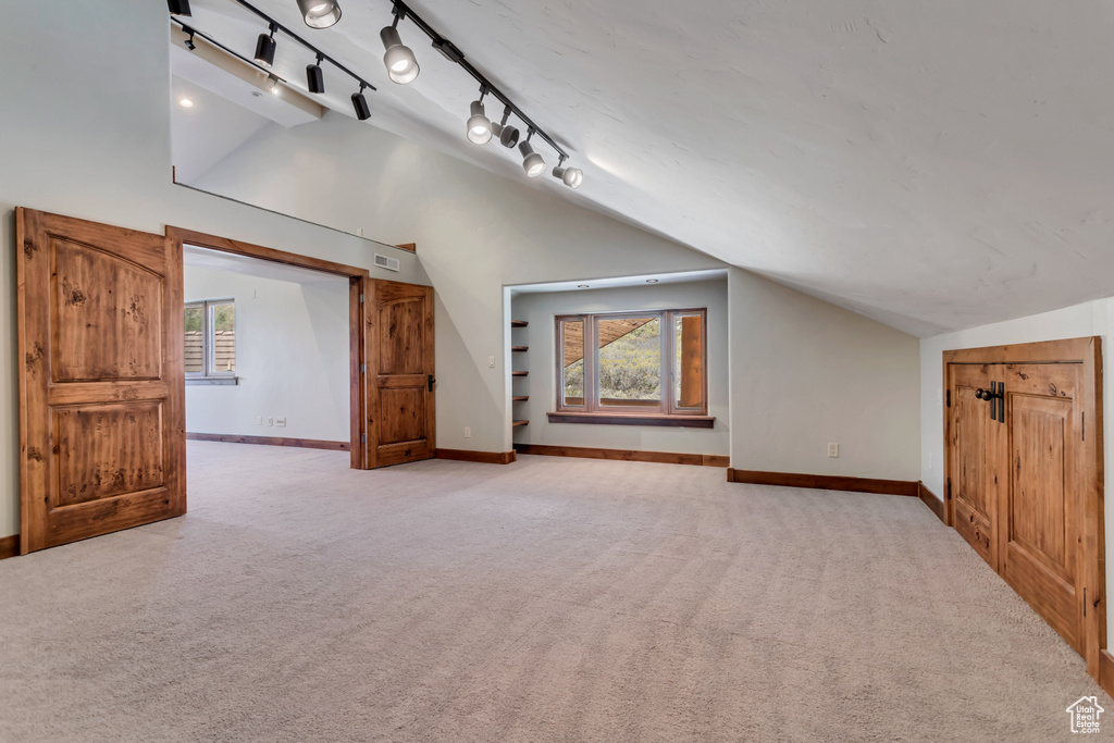 Bonus room featuring light colored carpet and lofted ceiling