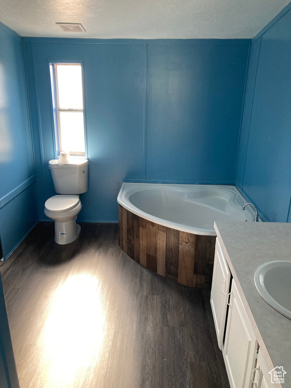 Bathroom with wood-type flooring, vanity, toilet, and a bathtub