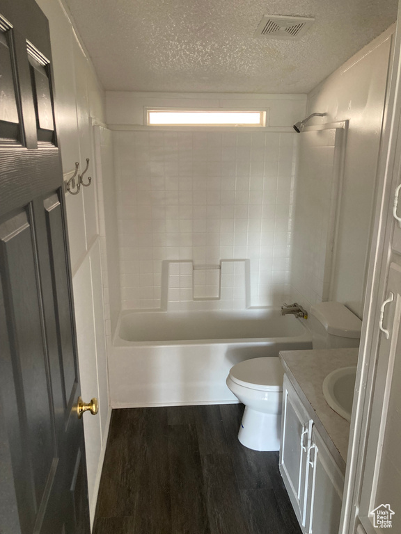 Full bathroom featuring toilet, vanity, hardwood / wood-style flooring, bathtub / shower combination, and a wealth of natural light