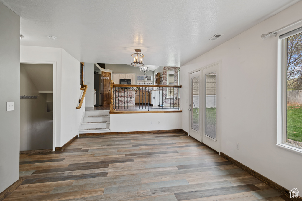 Interior space featuring hardwood / wood-style flooring, plenty of natural light, and a chandelier