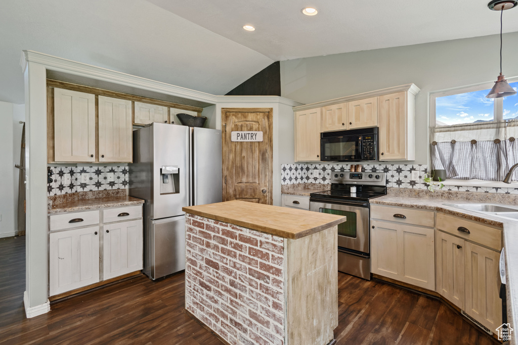 Kitchen with dark hardwood / wood-style flooring, appliances with stainless steel finishes, and backsplash