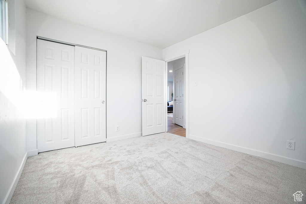 Unfurnished bedroom with a closet and carpet floors