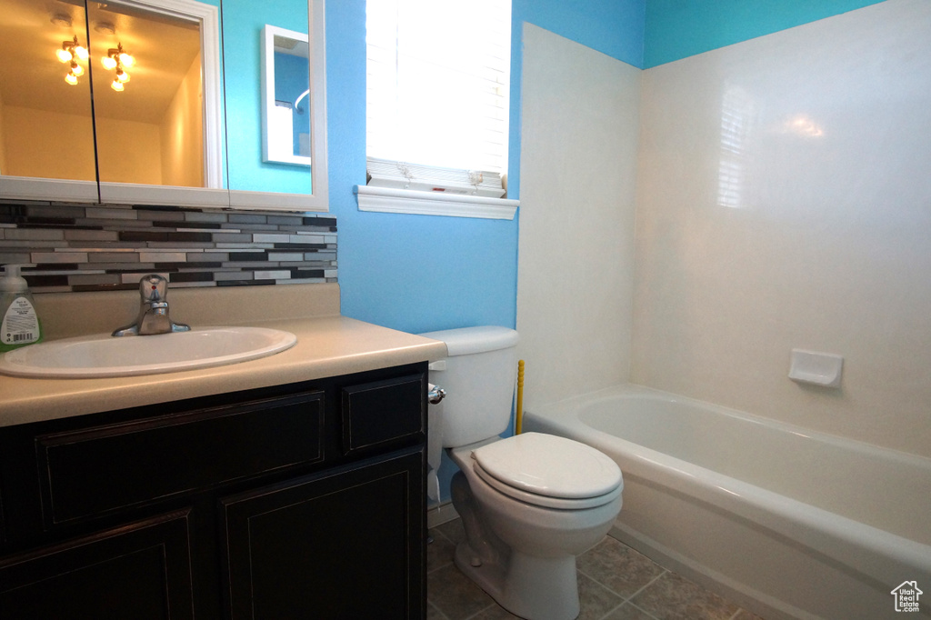 Full bathroom featuring tasteful backsplash, oversized vanity, tile flooring, tub / shower combination, and toilet