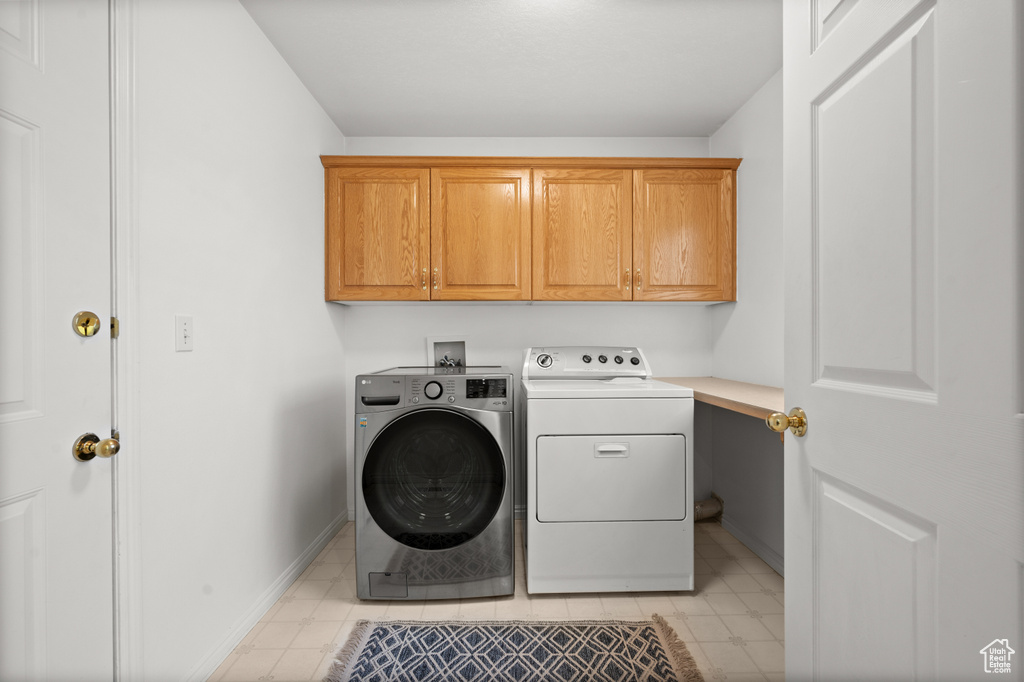 Washroom with cabinets, separate washer and dryer, washer hookup, and light tile floors