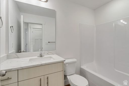 Full bathroom featuring washtub / shower combination, oversized vanity, and toilet