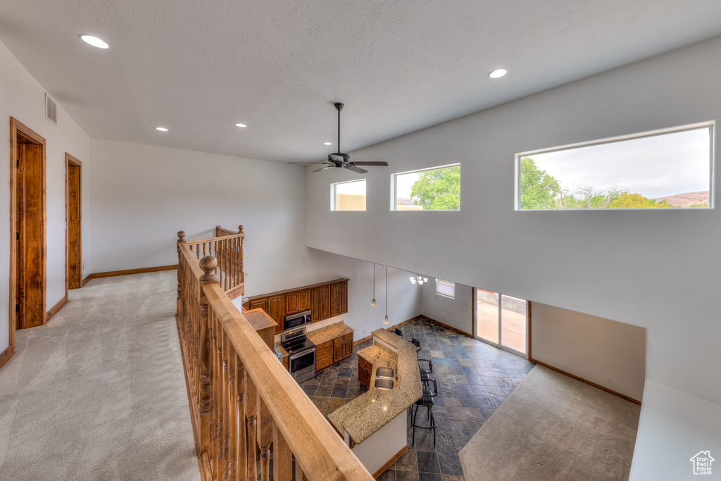 Carpeted living room featuring a textured ceiling and ceiling fan