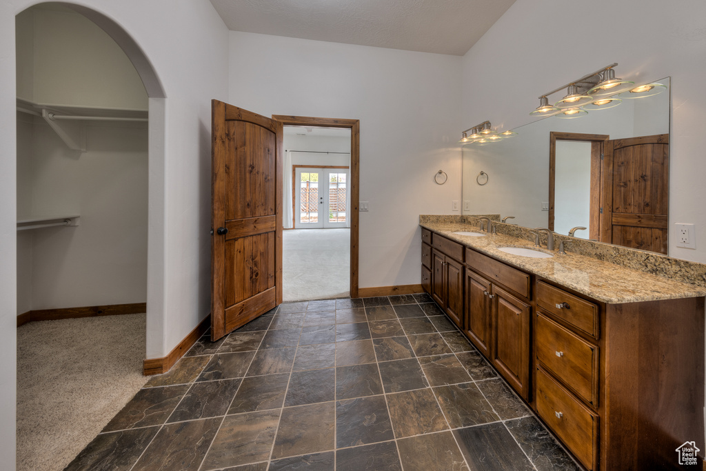 Bathroom featuring french doors, tile floors, and dual bowl vanity