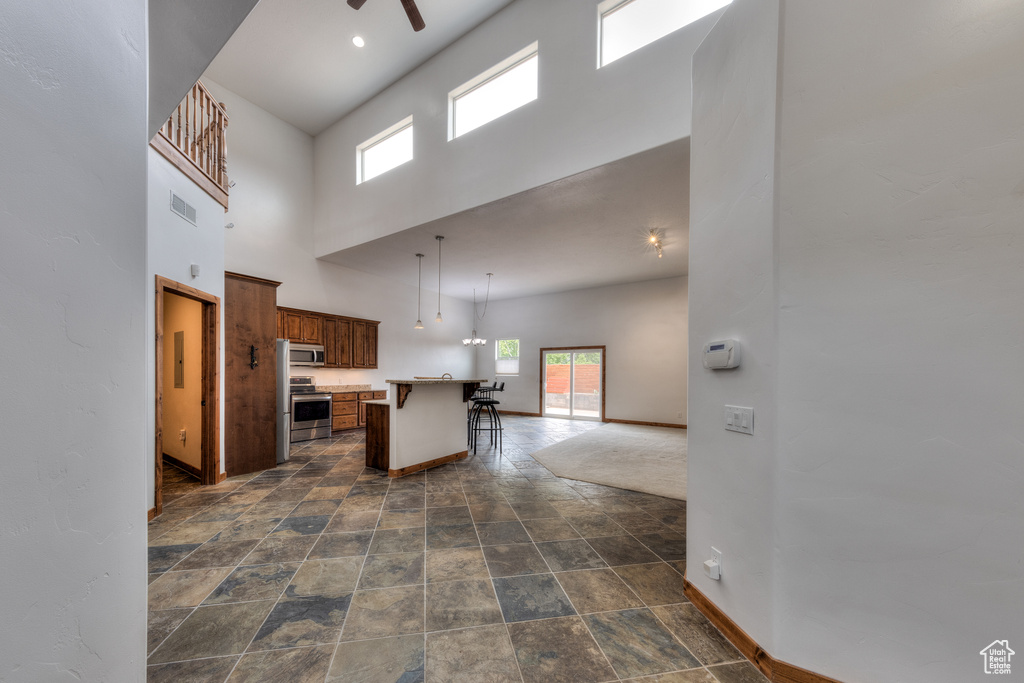 Interior space with ceiling fan and a towering ceiling