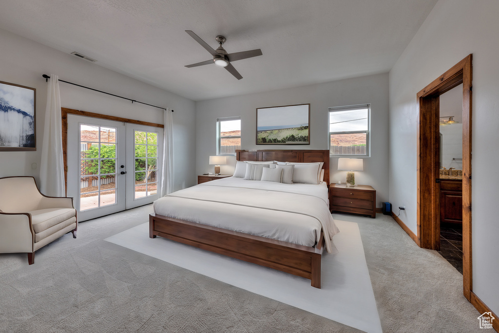 Bedroom featuring light colored carpet, french doors, ceiling fan, and access to exterior
