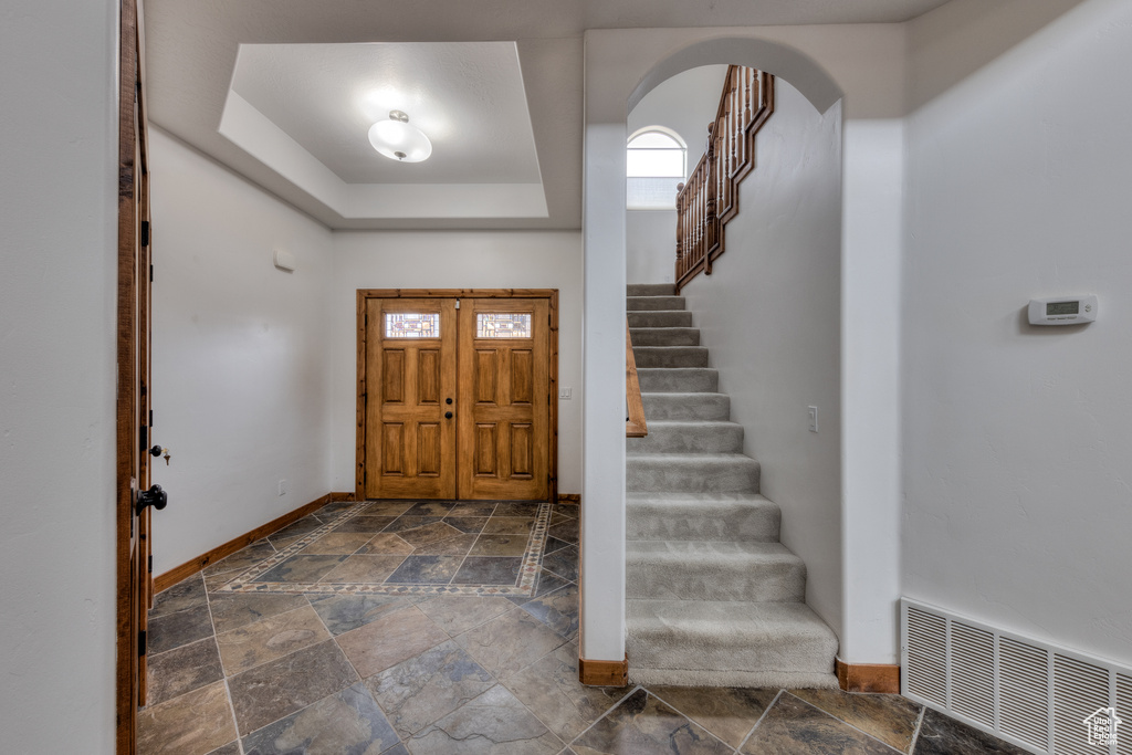 Tiled foyer with a tray ceiling