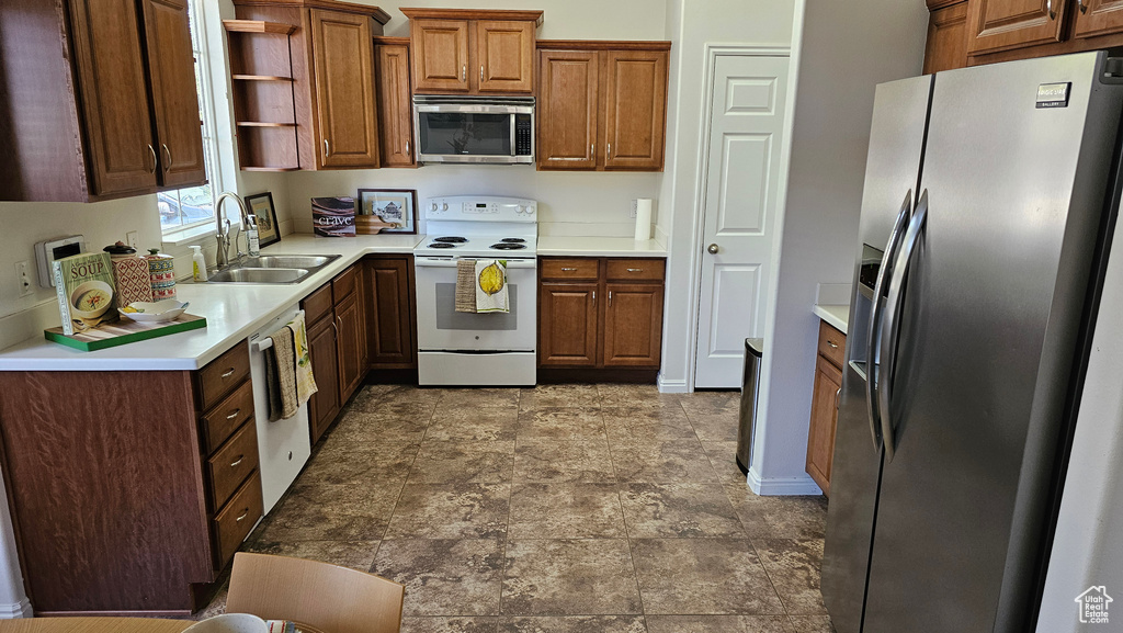 Kitchen with appliances with stainless steel finishes, sink, and tile flooring