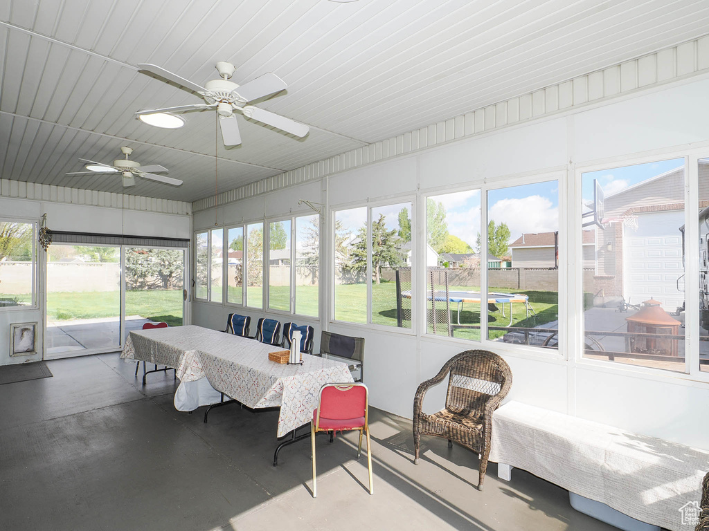 Sunroom / solarium with a wealth of natural light and ceiling fan