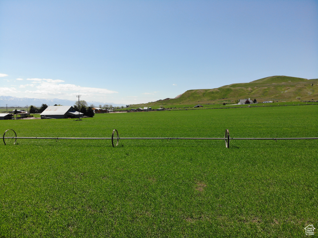 Surrounding community featuring a rural view, a lawn, and a mountain view