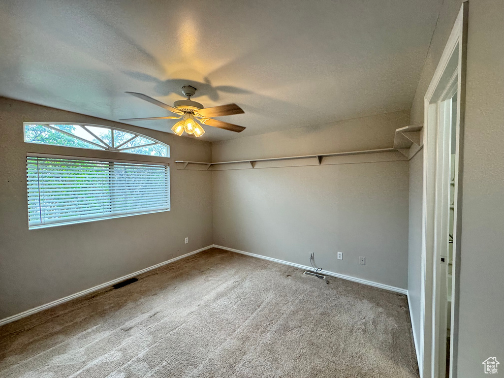 Unfurnished room featuring vaulted ceiling, ceiling fan, and carpet flooring