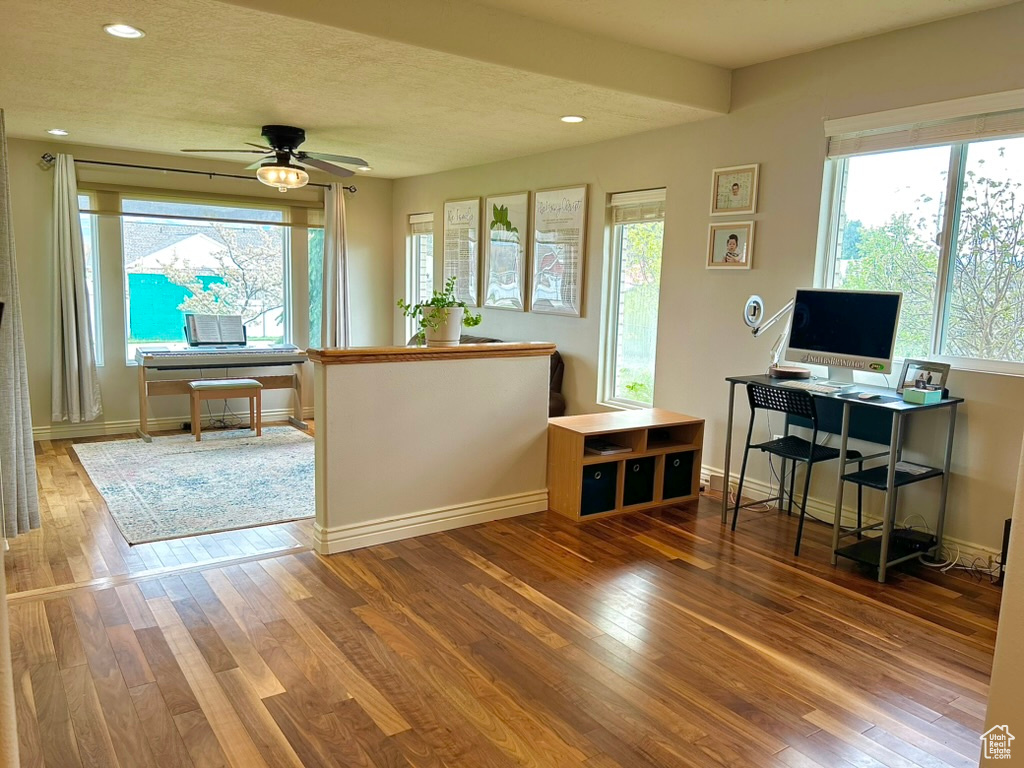 Office with wood-type flooring and ceiling fan