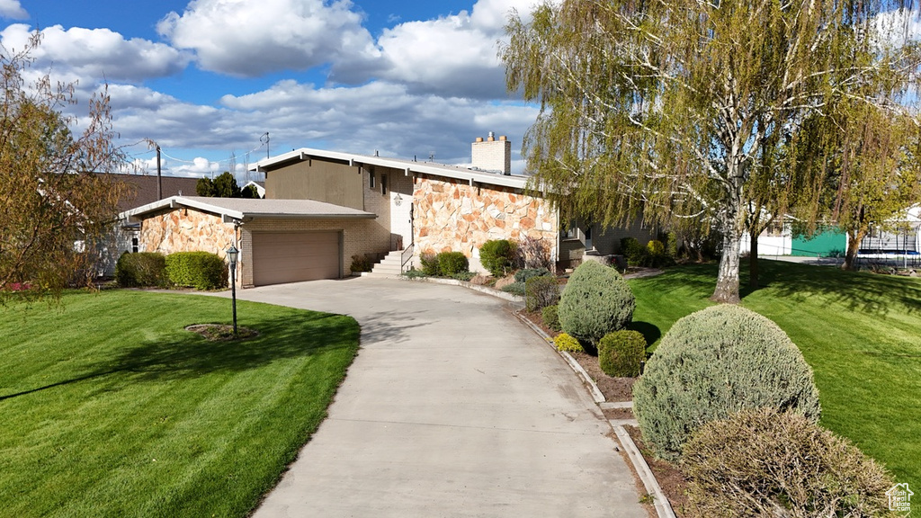 View of front facade with a garage and a front lawn