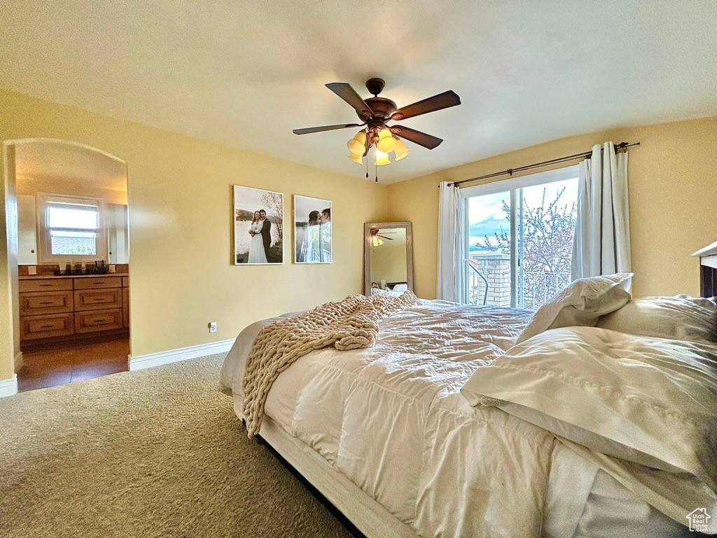 Bedroom with ceiling fan, tile floors, ensuite bathroom, and access to outside