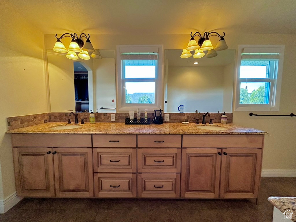 Bathroom featuring an inviting chandelier and dual vanity