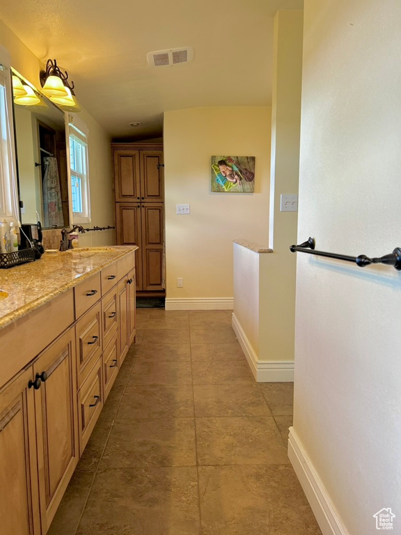 Bathroom featuring tile floors and vanity with extensive cabinet space