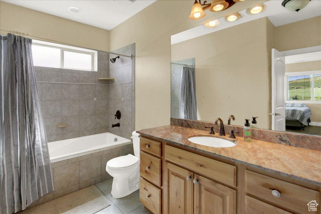 Full bathroom featuring large vanity, tile floors, toilet, and shower / bath combo with shower curtain