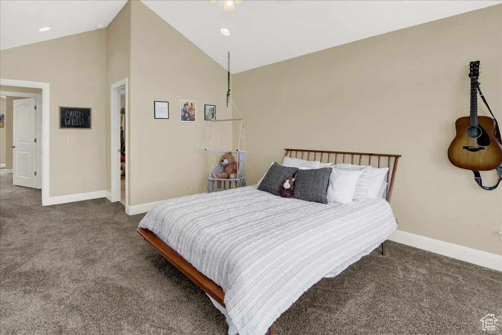 Bedroom with high vaulted ceiling and dark colored carpet