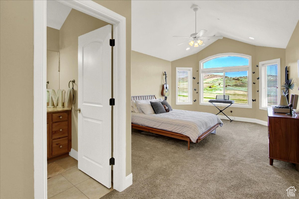 Carpeted bedroom with lofted ceiling, ceiling fan, and ensuite bath