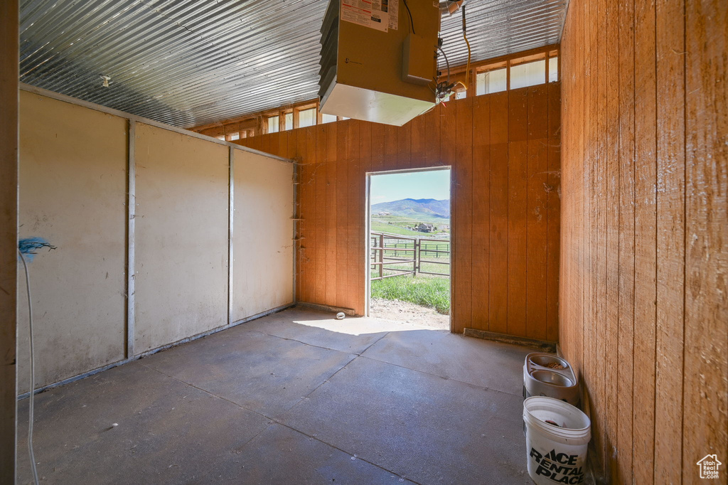 Interior space featuring concrete floors, a mountain view, and wooden walls