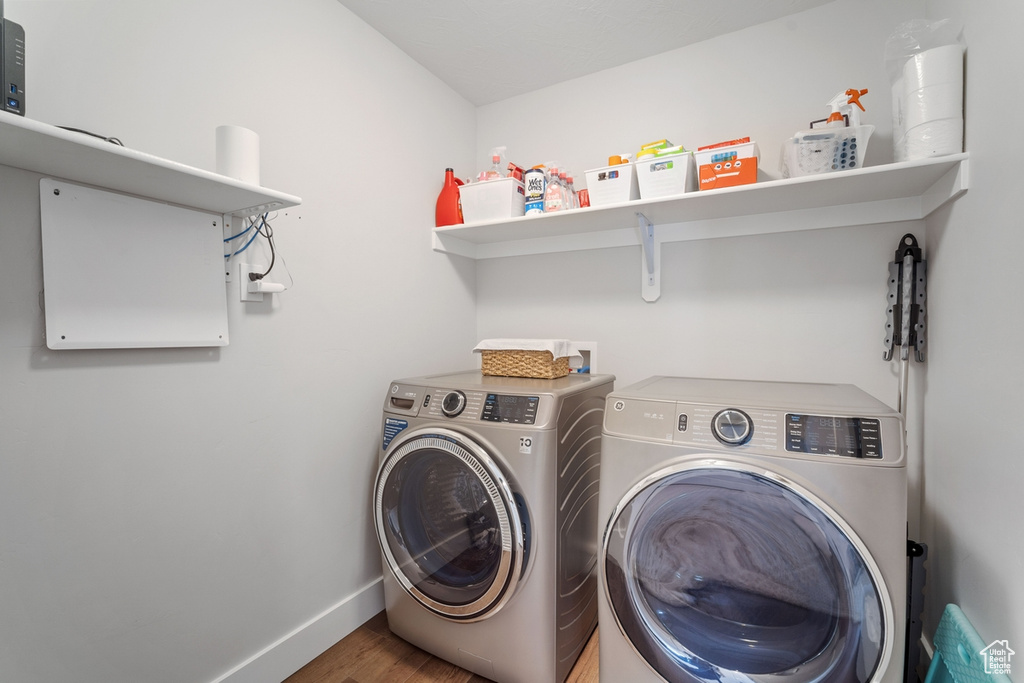 Laundry room featuring washer and clothes dryer, wood-type flooring, and hookup for a washing machine