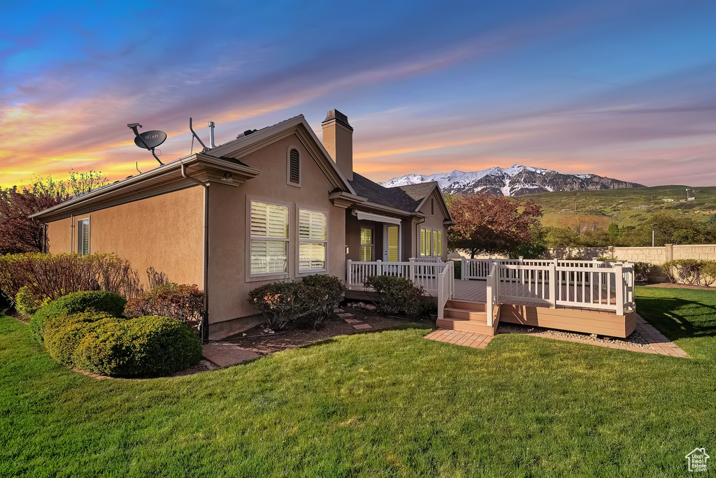 Exterior space featuring a yard and a deck with mountain view