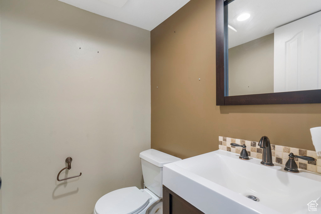 Bathroom with tasteful backsplash, vanity, and toilet