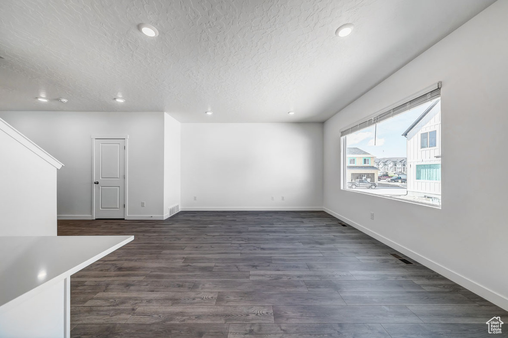 Unfurnished room featuring dark hardwood / wood-style floors and a textured ceiling