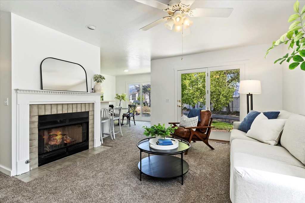 Living room featuring a tile fireplace and ceiling fan