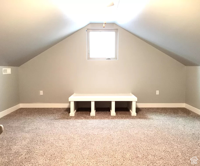 Bonus room with lofted ceiling and carpet flooring