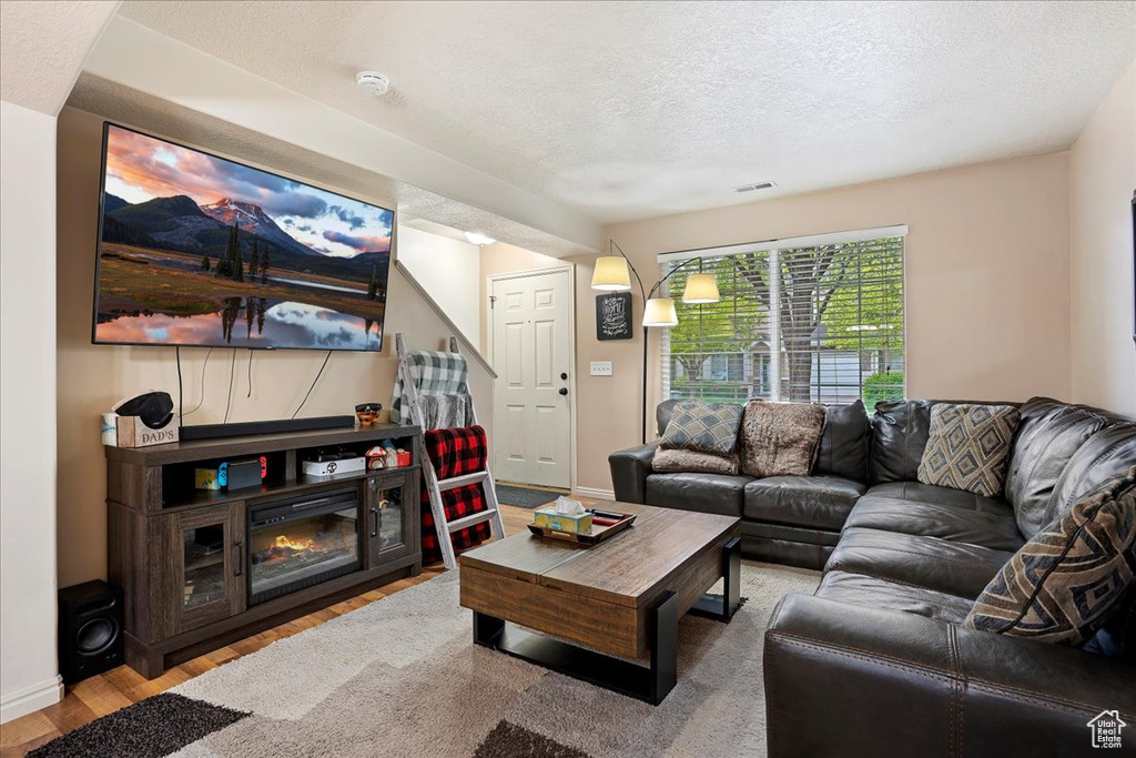 Living room featuring hardwood / wood-style floors and a textured ceiling