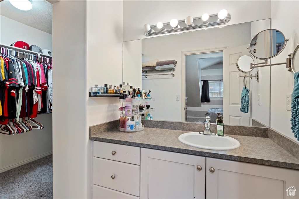 Bathroom with vanity with extensive cabinet space