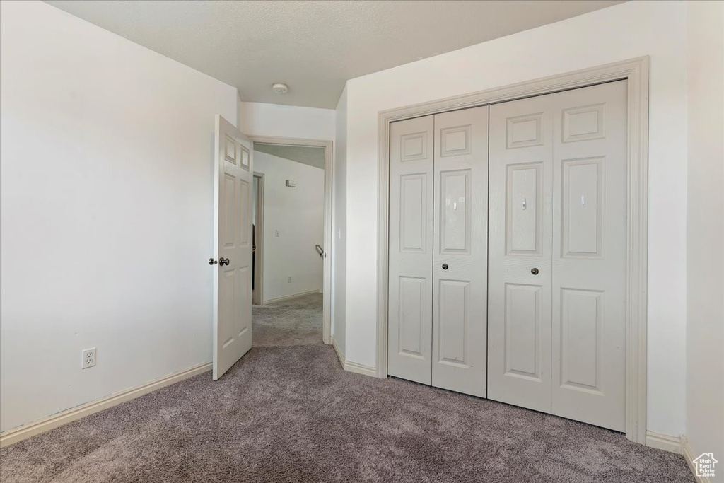 Unfurnished bedroom with a closet and carpet floors