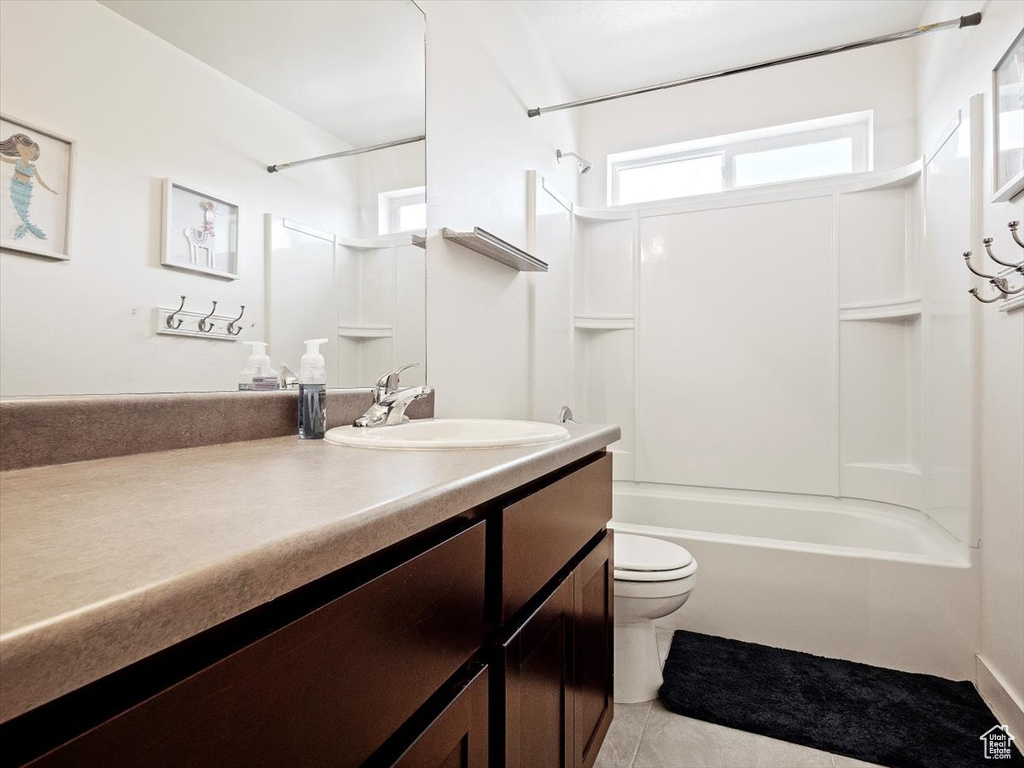 Full bathroom featuring vanity with extensive cabinet space, shower / tub combination, tile flooring, and toilet