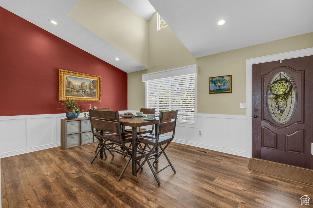 Dining space with lofted ceiling and dark hardwood / wood-style flooring