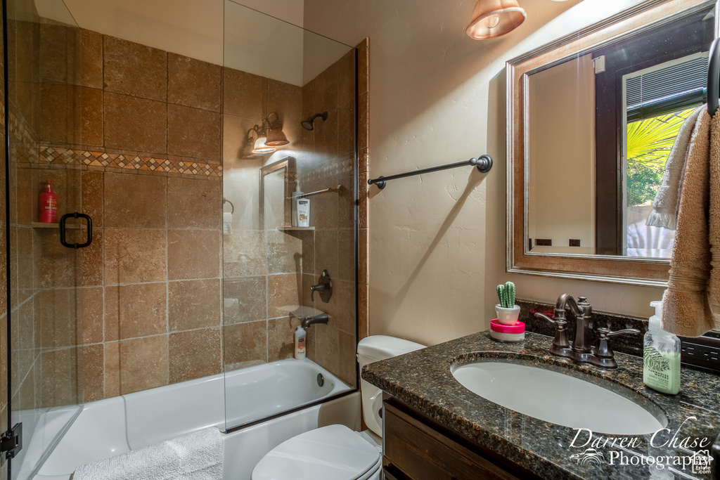 Full bathroom with shower / bath combination with glass door, vanity, and toilet