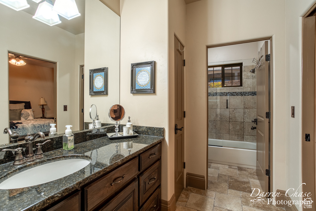 Bathroom featuring vanity, tile floors, and tiled shower / bath