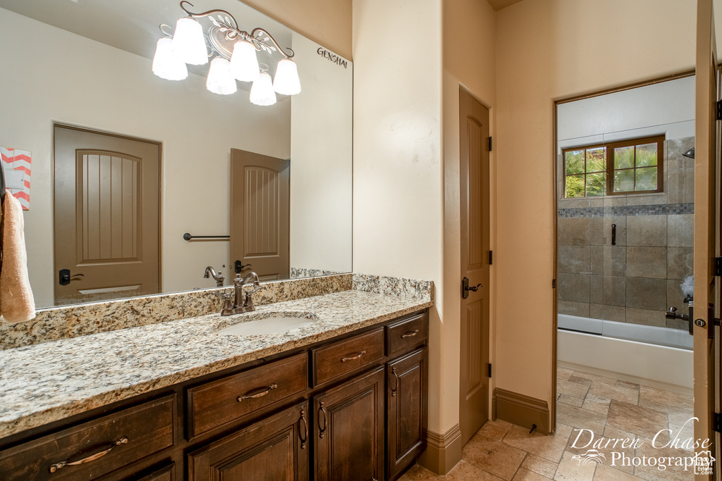 Bathroom featuring vanity, tiled shower / bath, and tile flooring