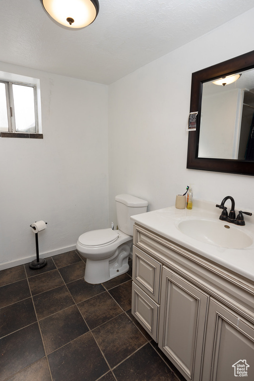 Bathroom with tile floors, vanity, and toilet