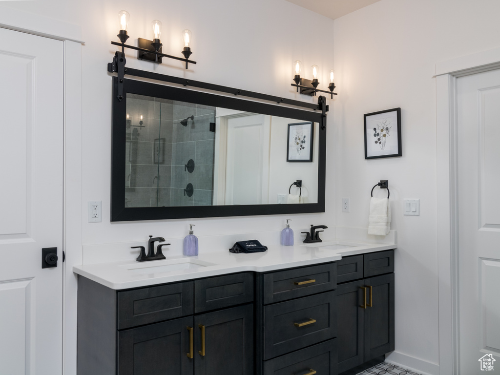 Bathroom featuring double sink vanity and a tile shower