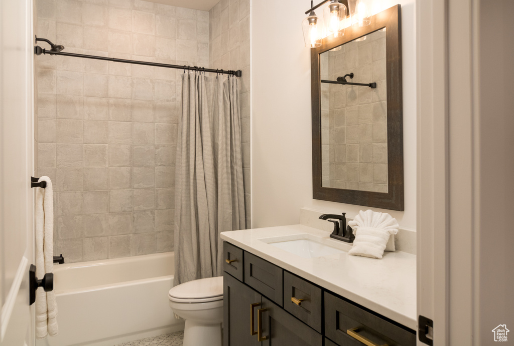 Full bathroom featuring shower / bathtub combination with curtain, toilet, and vanity with extensive cabinet space