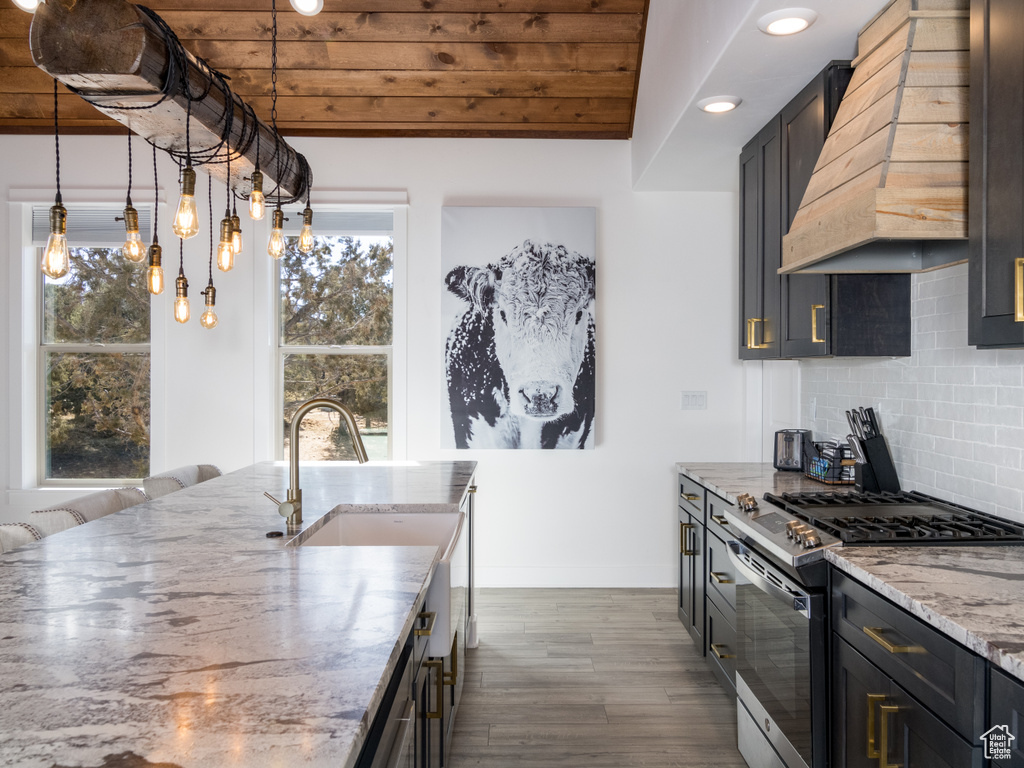 Kitchen featuring stainless steel range with gas stovetop, dark hardwood / wood-style floors, backsplash, custom range hood, and wood ceiling
