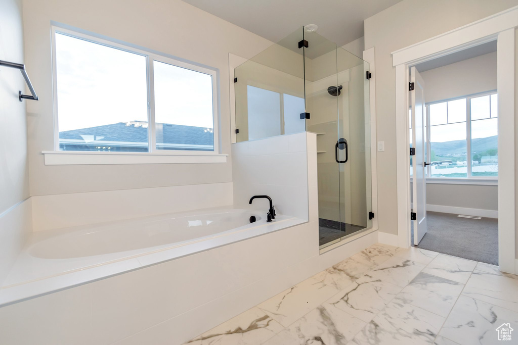 Bathroom with plenty of natural light, tile flooring, and plus walk in shower