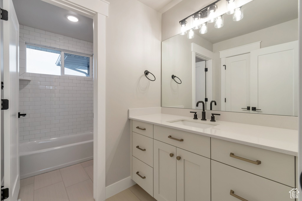Bathroom featuring tile flooring, tiled shower / bath, and vanity
