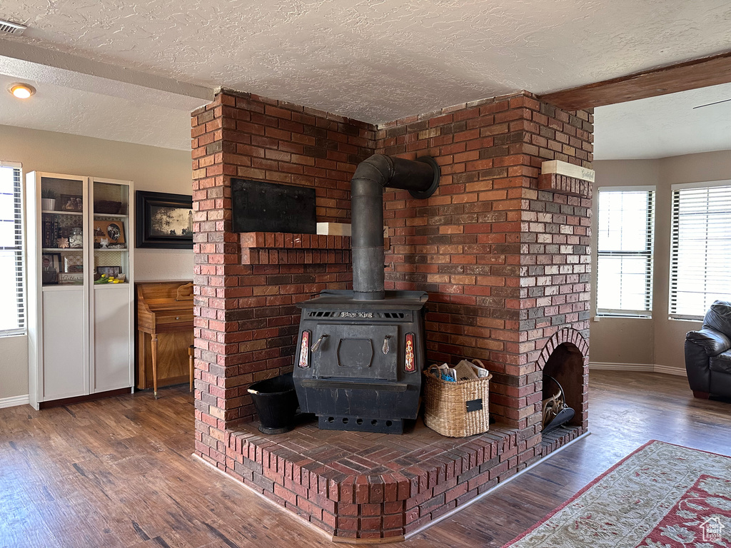Details with a wood stove, dark hardwood / wood-style flooring, and a textured ceiling